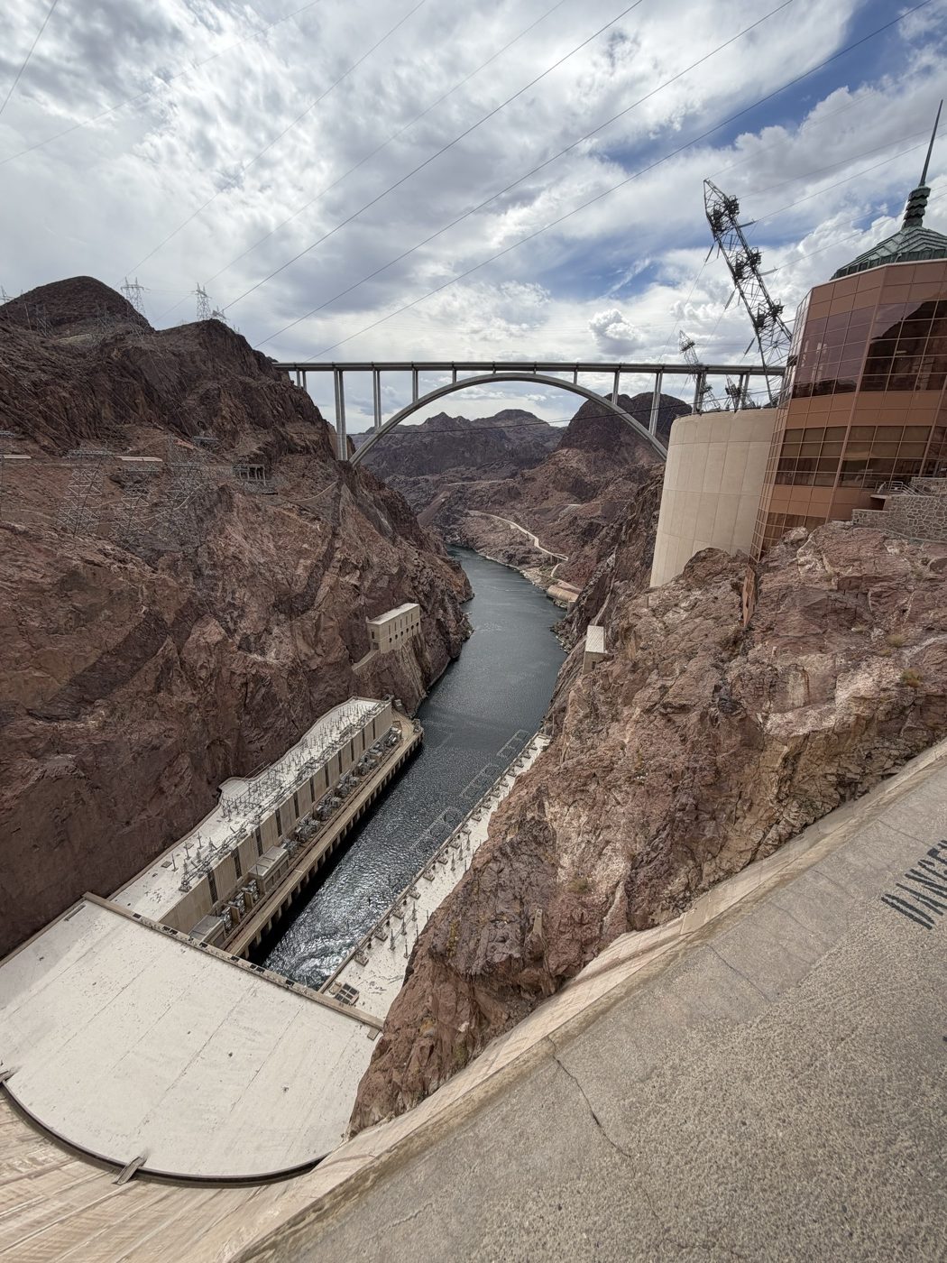 Looking down the canyon from the top of the dam to the river, the power plant and the arch bridge