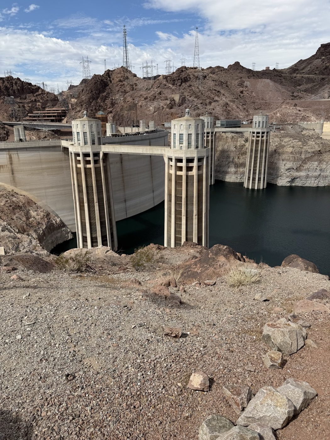 The intake towers standing in Lake Mead, with the pale band of the old waterline on the rock