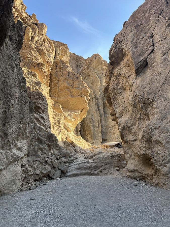 A narrow, sunlit slot between canyon walls