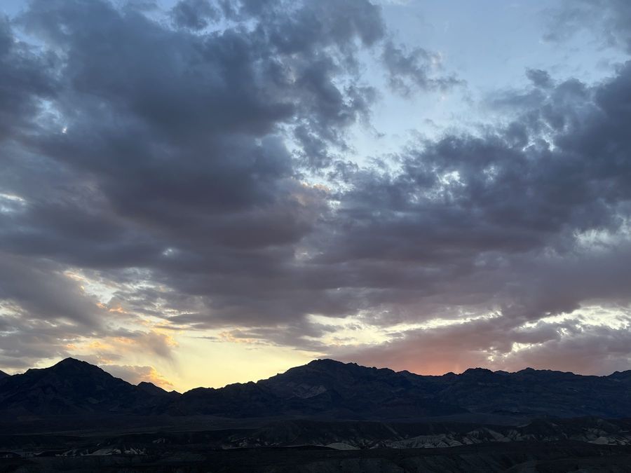 Storm clouds over dark mountains at dusk