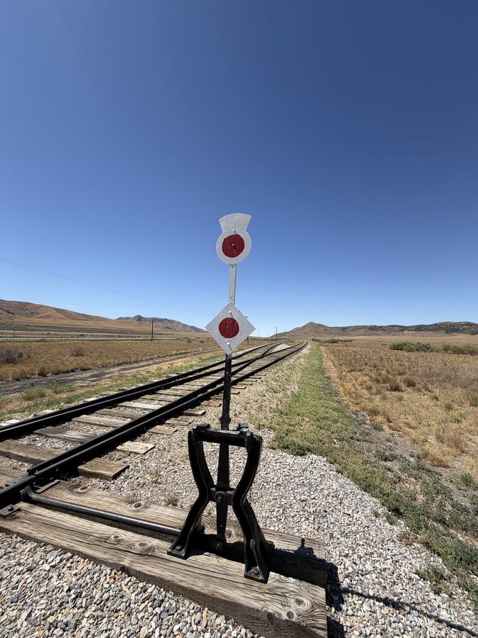 A railroad signal beside the track in open country