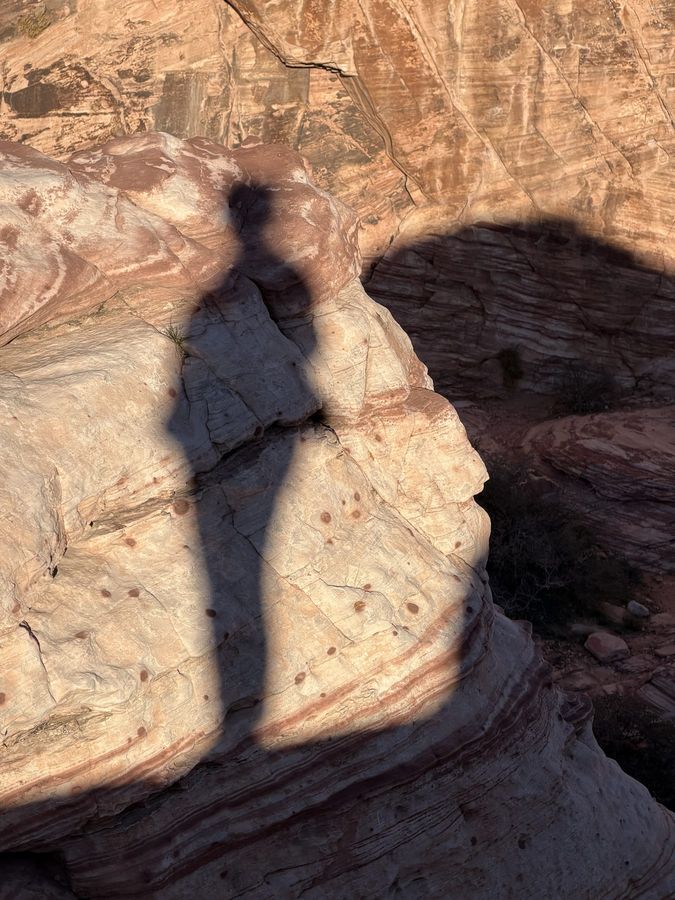 A long shadow on striped sandstone